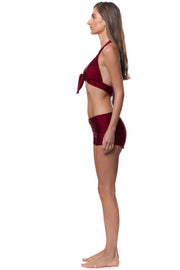 Bella Paradise retro halter bikini top in deep cardinal red shown on model side view with matching shorts