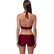 Back view of woman wearing a burgundy retro halter bikini top and matching shorts swimsuit