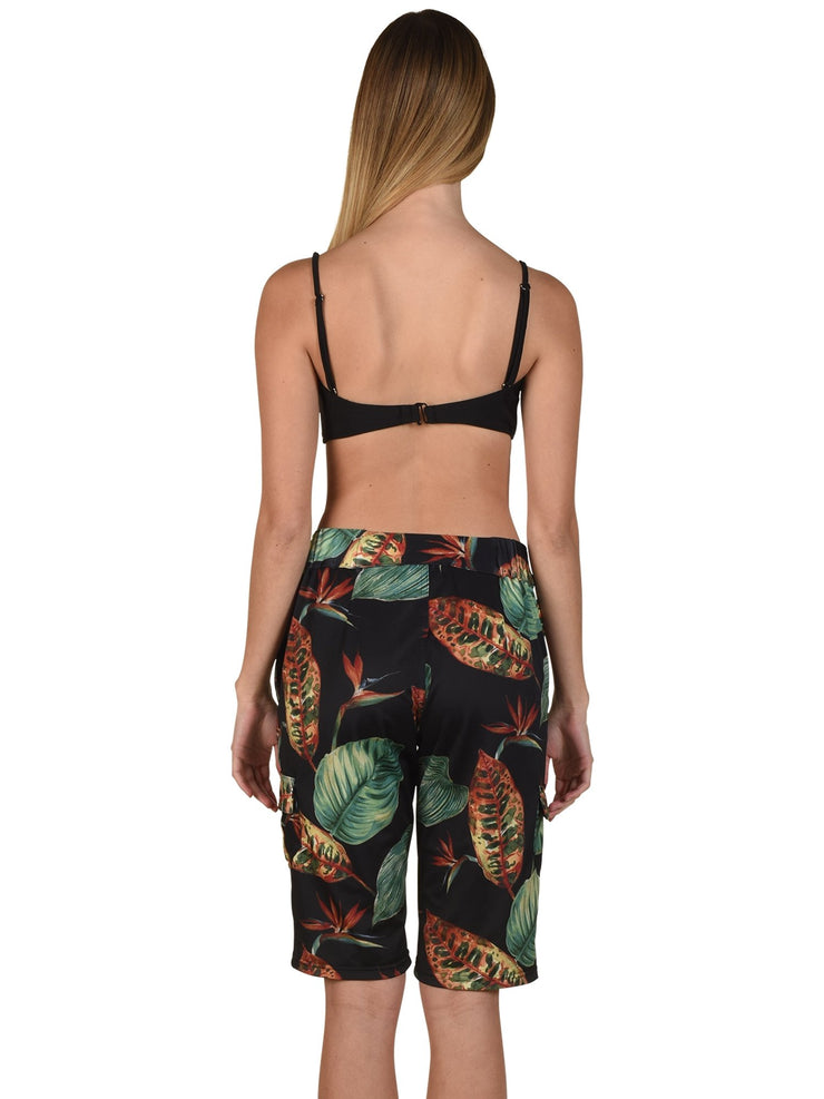 Back view of woman wearing luxury women's board shorts with tropical leaf print by Bella Paradise
