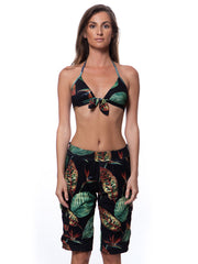 Bella Paradise luxury women's board shorts with tropical leaf print worn with matching bikini top