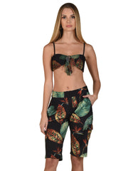 Model wearing Bella Paradise luxury women's board shorts with tropical leaf print and fitted style