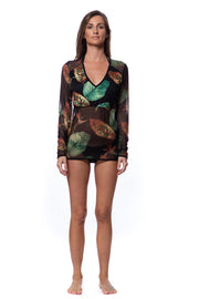 Bella Paradise long sleeve tropical rash guard with vibrant green and brown leaf print on model